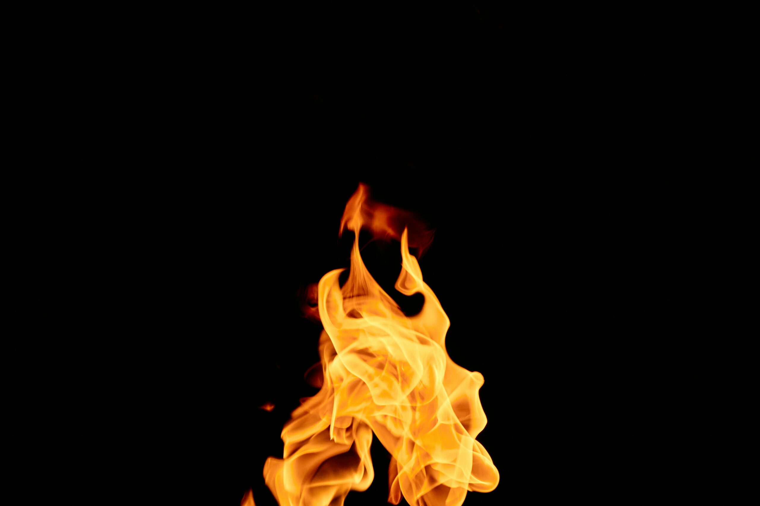 A captivating image of vibrant flames isolated against a dark black background.